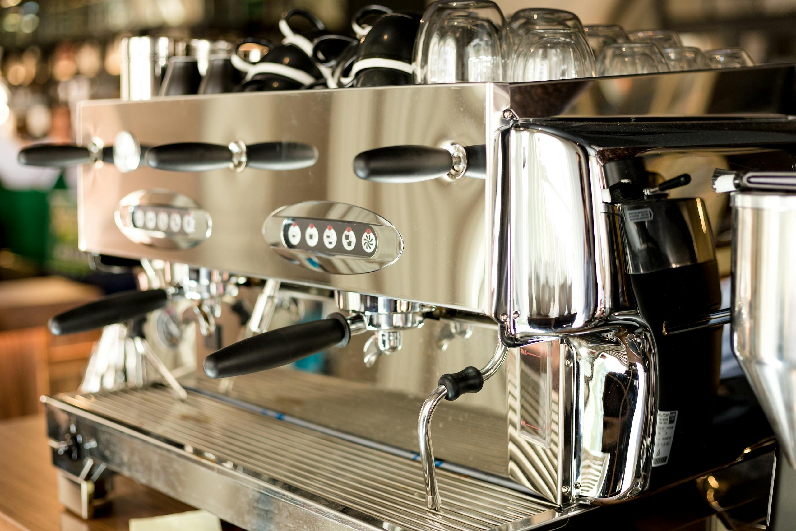 A sleek and modern stainless steel coffee machine in a contemporary cafe setting.